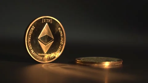 Gold Crypto coin Etherium on the table with reflection on the surface. White man Stock-Footage 134522102