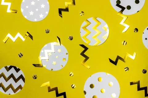 Gold different shape confetti on yellow background. Festive backdrop. Top vie Stock Photos