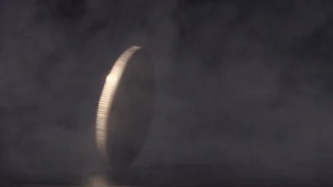 Gold Doge coin spinning through smoke in slow motion against black Stock Footage 217947257