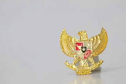 Gold eagle badge with shield and wings on gray background Stock Photos
