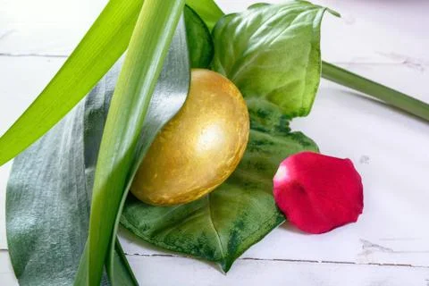 Gold easter eggs among green leaves Stock Photos