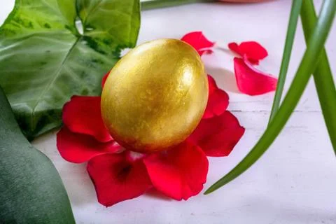 Gold easter eggs among green leaves Stock Photos