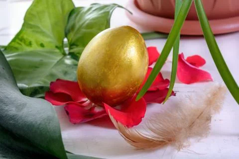 Gold easter eggs among green leaves Stock Photos