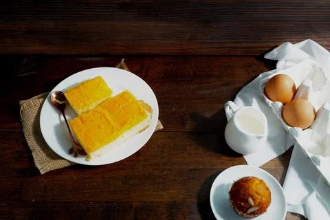 Gold egg yolk thread cakes, banana cake on the wooden table in cafe Stock Photos