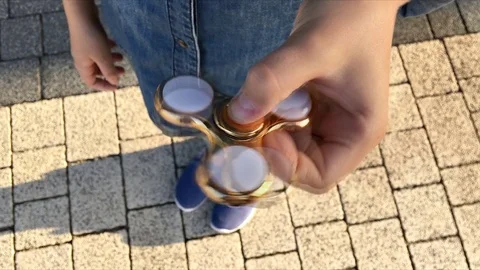 Gold fidget spinner in hand. Popular trendy toy close-up. Stock Footage 78232633