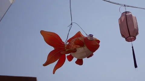Gold fish shaped lamp turning in the wind,4K Video stock 296594039