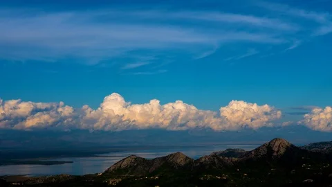 Gold fluffy clouds move above a mountain and the surface of the water time lapse Stock Footage 120783726