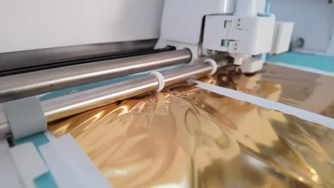 Gold foil Cricut Explore 4 cutting metallic sheet in close-up DIY craft Vidéo 332612238