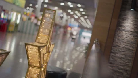 Gold Frames Glowing Warmly with Blurred Mall Interior and Reflective Floors Stock Footage 302587460