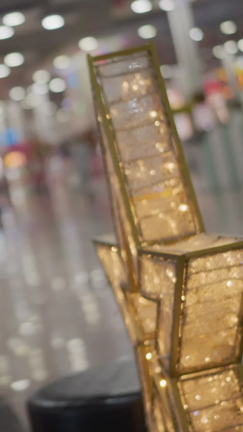 Gold Frames Glowing Warmly with Blurred Mall Interior and Reflective Floors Stock Footage 310576448
