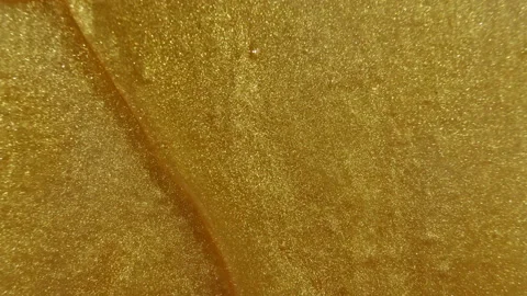 Gold gel fluid with flowing down on surface. Molten gold. Sparkling yellow Stock Footage 148440837