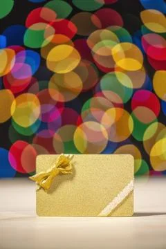 Gold gift card against multi-colored bokeh Foto stock