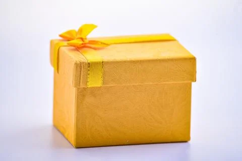A gold giftbox on the white table Stock Photos