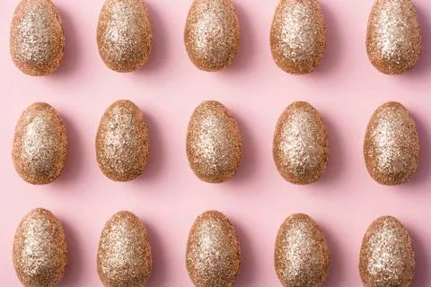 Gold glitter easter eggs on a pastel pink background. Happy Easter Stock Photos