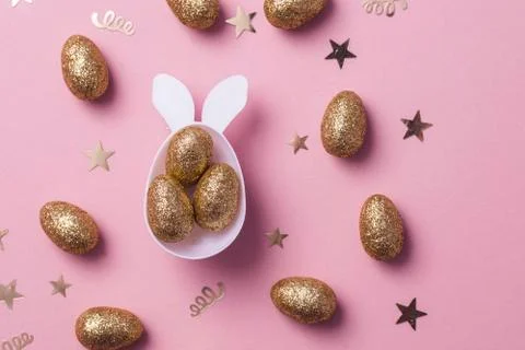 Gold glitter eggs in a white easter bunny egg shape with ears Stock Photos