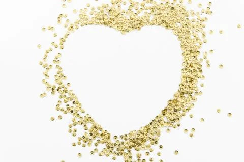 Gold glitters , scattered in disarray lined heart shape isolated on white Stock Photos