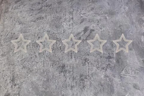 Gold, gray, silver five star shape on the gray concrete background. The bes.. Stock Photos