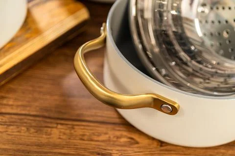 Gold handle ceramic pot with steaming insert Foto stock