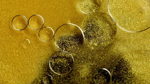 Gold Ink Particles abstract background with oil bubbles, close-up 库存影片 130375410