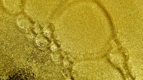 Gold Ink Particles abstract background with oil bubbles, close-up Stock Footage 130377216