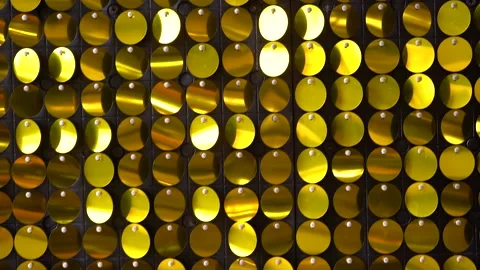 Gold iridescent sequins that reflect light.  Video stock 159227521