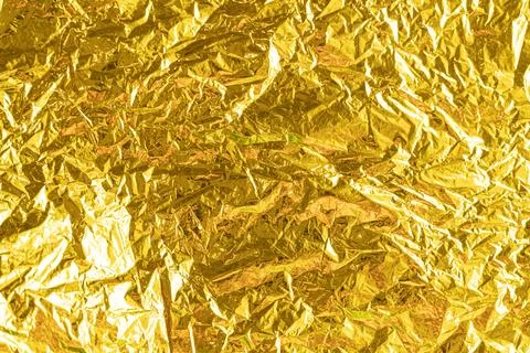Gold leaf background texture with shiny crumpled uneven surface Stock Photos