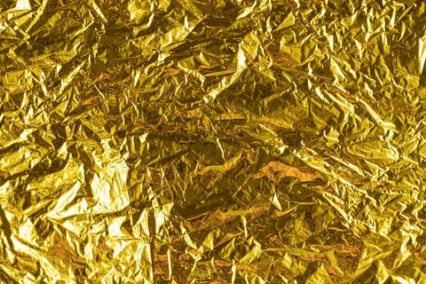 Gold leaf background texture with shiny crumpled uneven surface Stock Photos