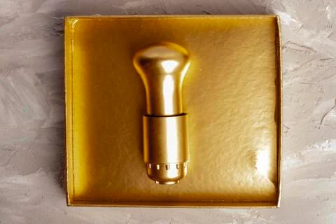 Gold light bulb in box, flat lay. Business and money concept Stock Photos