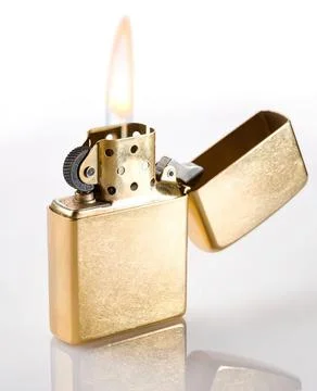 Gold lighter with flame and open lid on white background Stock Photos