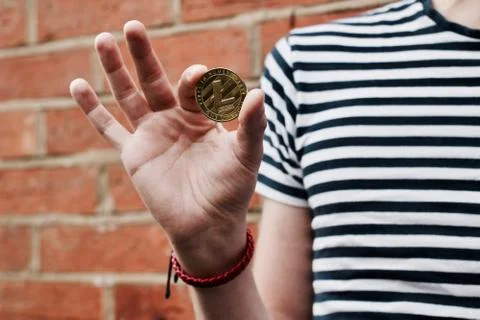 Gold Litecoin in hand Stock Photos