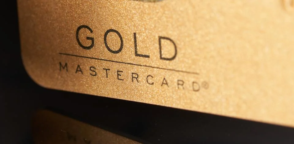 Gold mastercard credit card on glass table with reflection Stock Photos