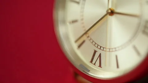 Gold metallic second on clock face. Red background for copy space Stock Footage 193735524