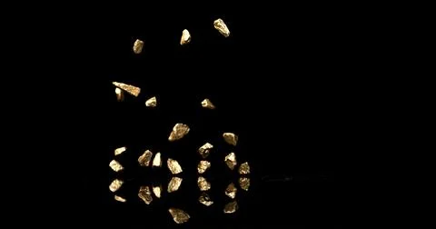 Gold Nugget Falling on Black Background Stock Photos