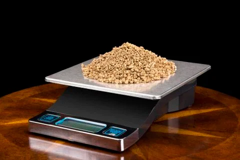 Gold nuggets on scale Stock Photos