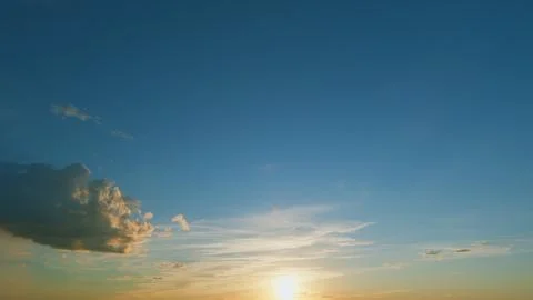 Gold orange sunset sky cloudscape. Dramatic sunset. Summer sky. Timelapse. Stock Photos