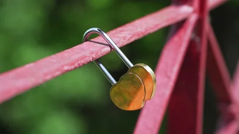 Gold padlock in the shape of two hearts. bridge of lovers. romantic symbol Stock Footage 232898428