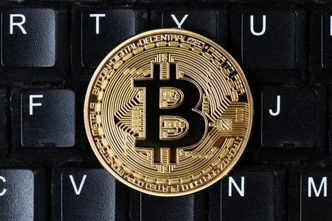 Gold physical Bitcoin cryptocurrency on computer keyboard. Stock Photos