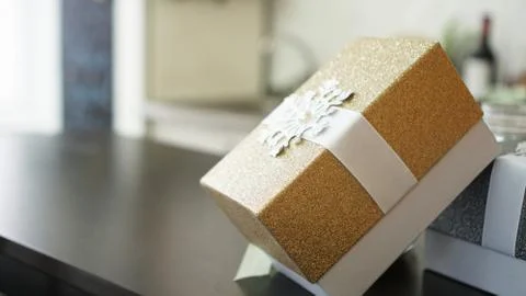 Gold present box on wood table with blurred background, Holiday concept Stock Photos