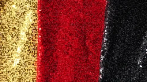 Gold, red and black sequined fabric  for German patriotic design. Stock Footage 342842595