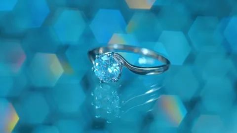 Gold ring with a diamond sparkling in the light against a beautiful blurred back Stock Footage 259869442