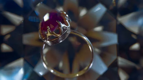 A gold ring with a large red ruby rotates and sparkles in the rays of light Stock Footage 151999199