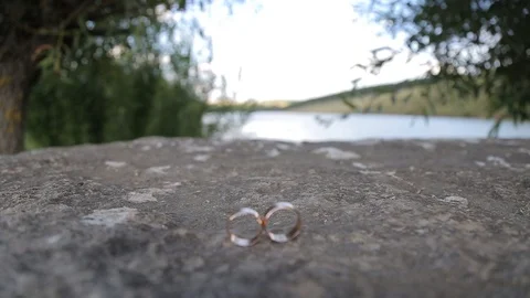 Gold ring lie on the stone surface Vidéo 123780448