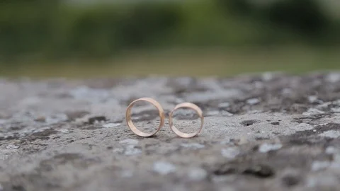 Gold ring lie on the stone surface in sunny day Vidéo 123781978