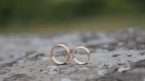 Gold ring lie on the stone surface in sunny day Vidéo 123782008