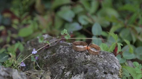 Gold ring lie on the stone surface in sunny day Видео 123895763