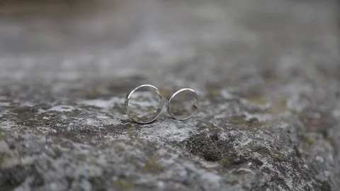 Gold ring lie on the stone surface in sunny day Видео 123896854