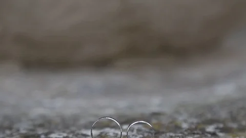Gold ring lie on the stone surface in sunny day Видео 123896931