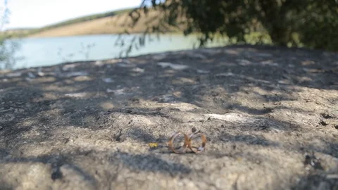 Gold ring lie on the stone surface in sunny day Stockbeeldmateriaal 123898237