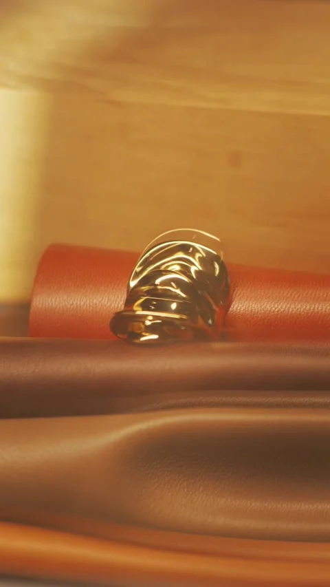 Gold ring placed on stacked rolls of colorful leather Stock Footage 331774697