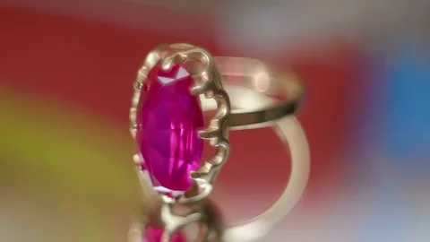 A gold ring with a red ruby shines in the rays of light on a mirror surface Stock Footage 268908413